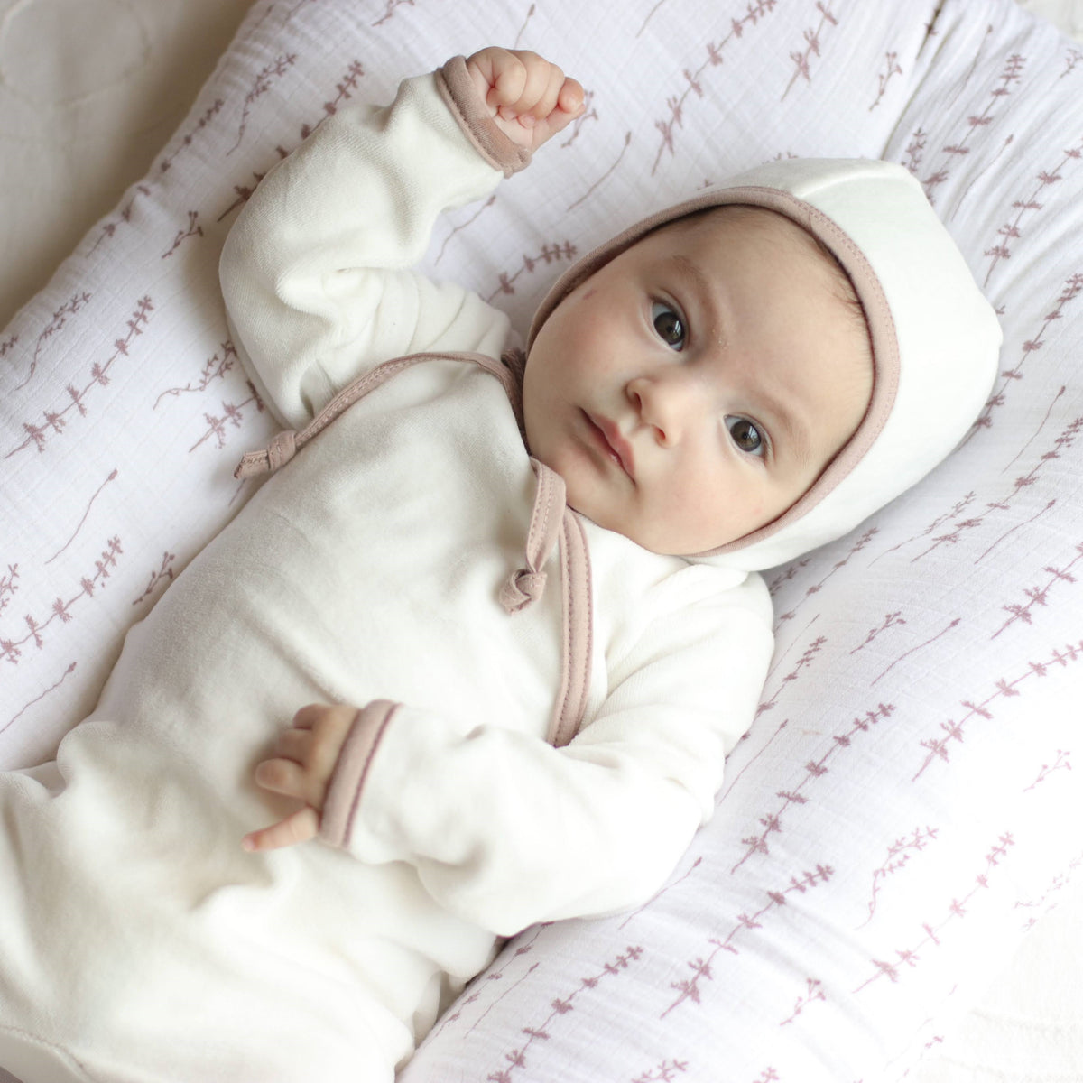 Newborn baby peacefully resting in soft Ely's and Co essentials